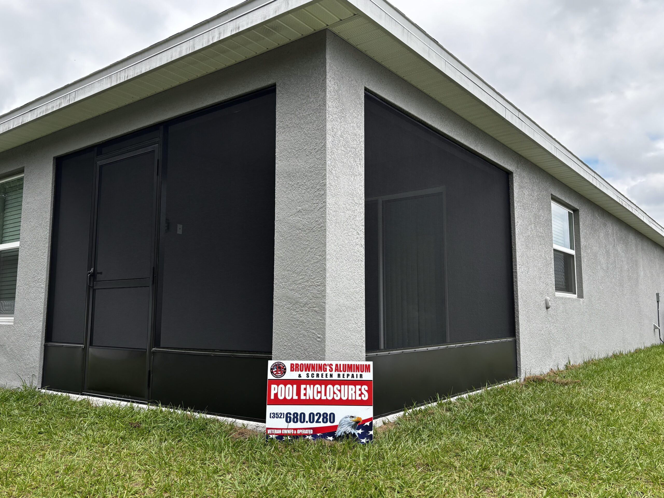 Black aluminum screen enclosure installed on side of Florida home