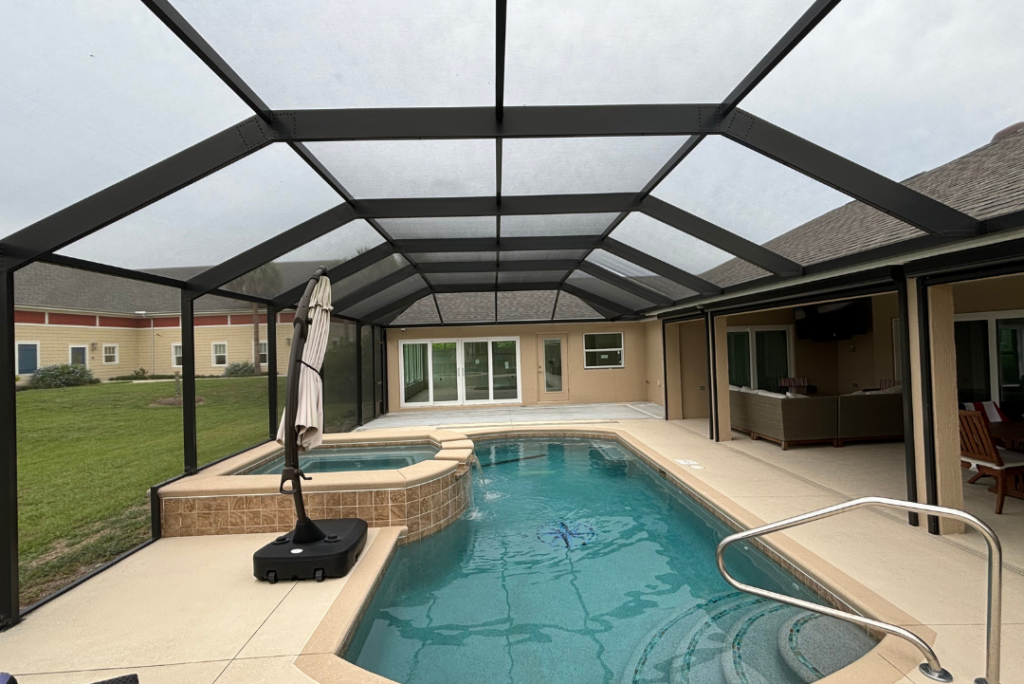 Pool screen enclosure covering a backyard pool and patio area in Florida